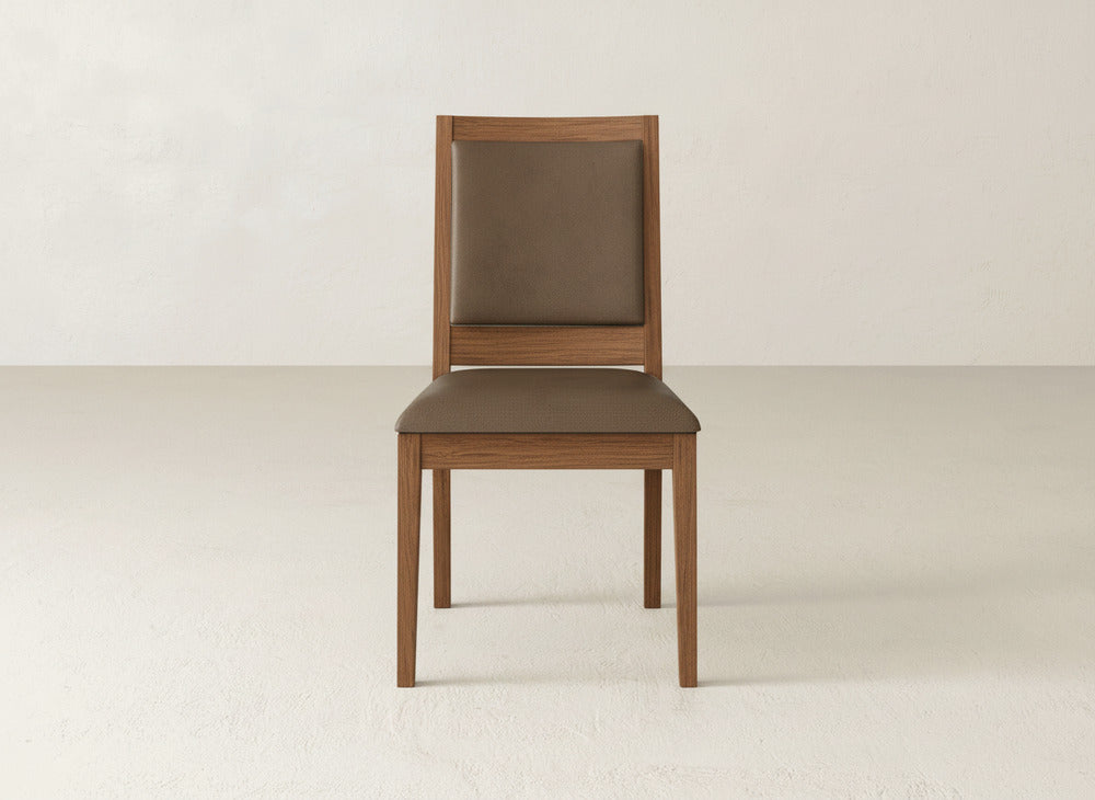 The Gina Side Dining Chair by James+James features maple wood construction with a brown cushioned seat and backrest, shown in a light, minimalist room with plain walls and flooring.