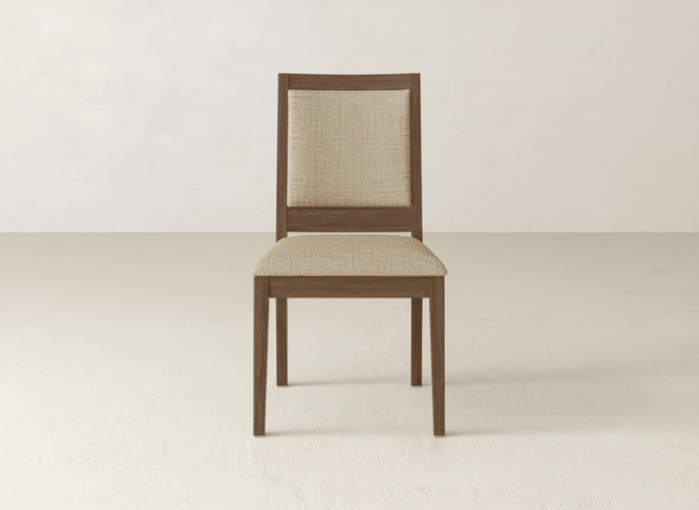 The James+James Gina Side Dining Chair is a modern maple wood chair with a light brown upholstered seat and backrest, shown against a plain off-white background.