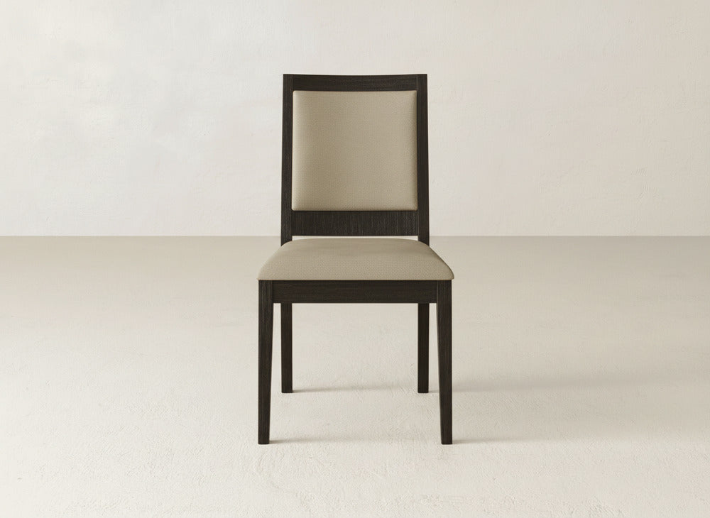 The James+James Gina Side Dining Chair features a straight back, dark maple wood frame, and light beige upholstered seat and backrest, shown on a plain light floor against a neutral wall.