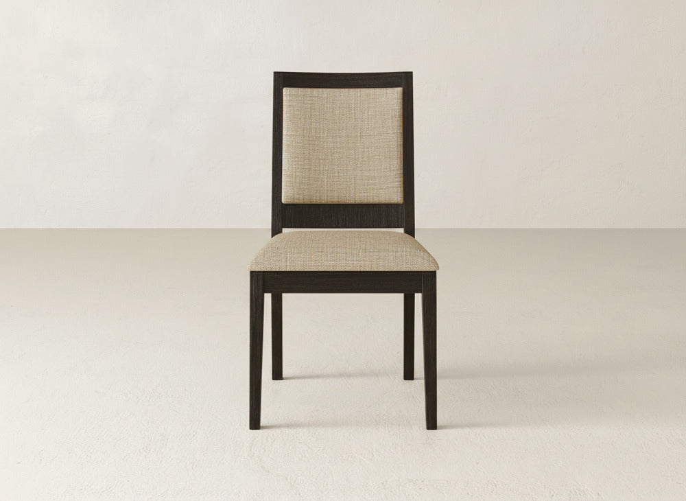 The James+James Gina Side Dining Chair pairs a dark maple wood frame with a light beige upholstered seat and backrest, offering an elegant touch to any neutral-toned dining space.