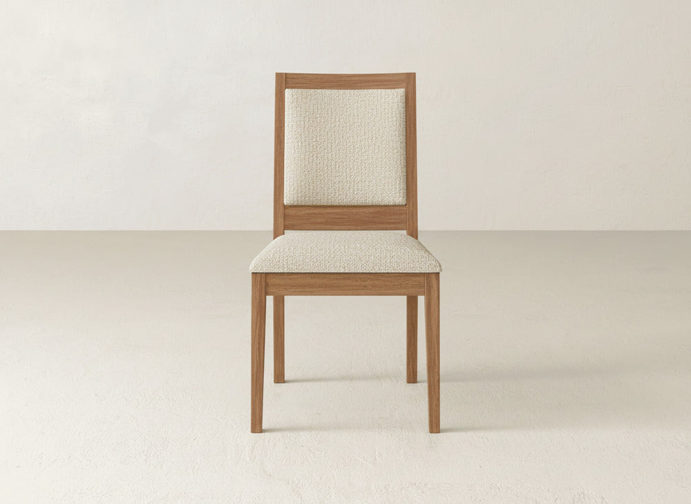 The Gina Side Dining Chair by James+James features a simple modern design, crafted from maple wood with light beige cushioned seat and backrest, displayed against an off-white background.