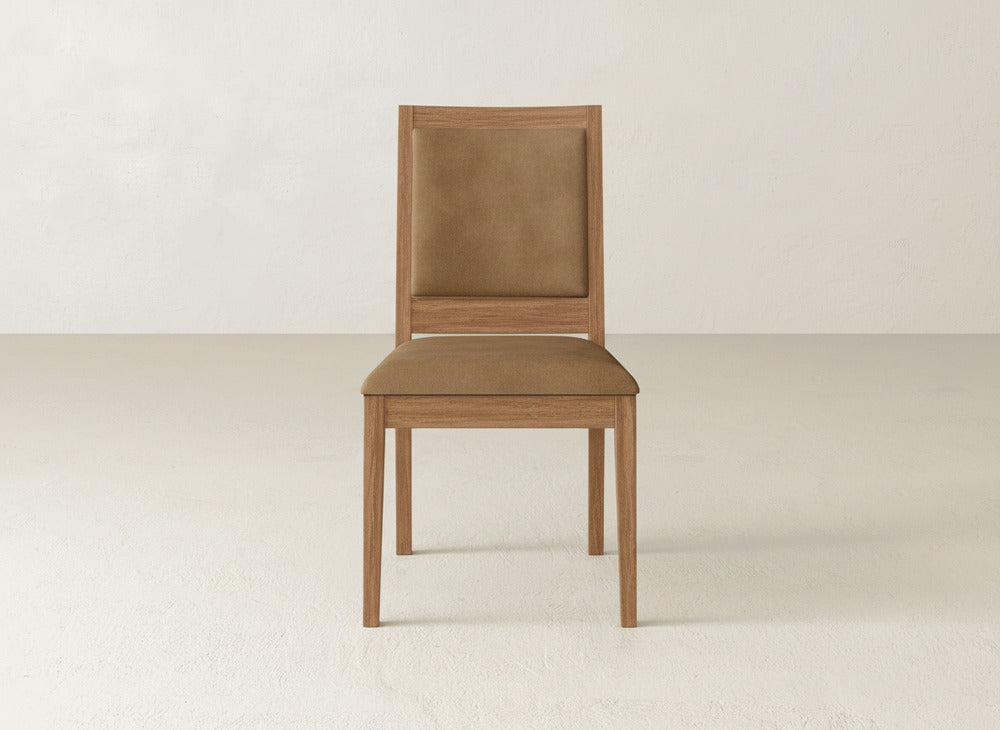 The Gina Side Dining Chair by James+James features a maple wood frame with brown cushioned seat and backrest, set on a light floor against an off-white wall.