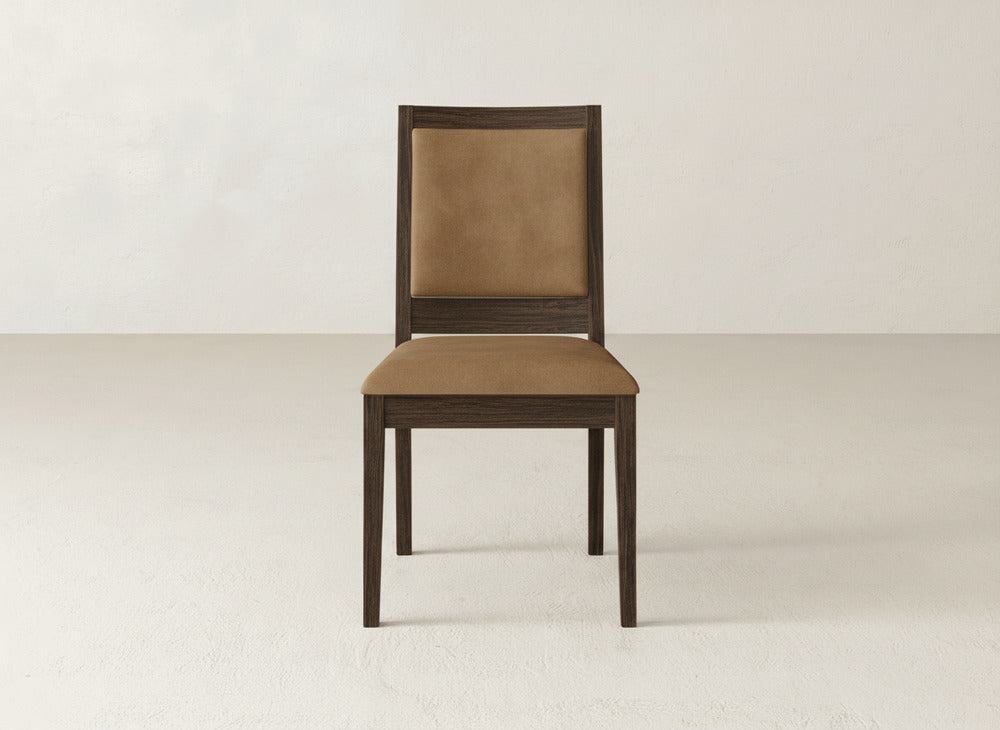 The Gina Side Dining Chair by James+James is made of maple wood and features a brown cushioned seat and backrest, shown in an empty room with light floors and walls.