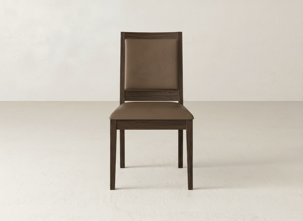 The Gina Side Dining Chair by James+James features maple wood construction with brown cushioned seat and backrest, shown on a light floor beside a neutral wall.