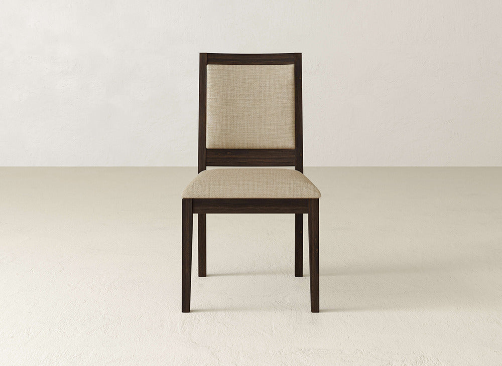 The James+James Gina Side Dining Chair showcases a dark brown maple frame with light beige upholstery, set on a light floor and backed by a plain off-white wall.
