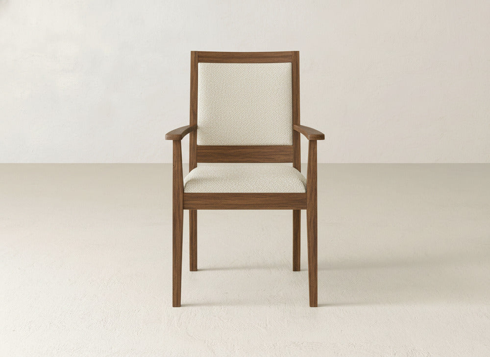 The Gina Arm Dining Chair by James+James is a contemporary maple wood chair with straight armrests and legs, plus a light beige upholstered seat and backrest, shown against an off-white background.