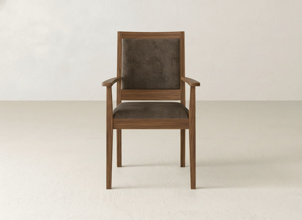 The Gina Arm Dining Chair by James+James is a modern maple chair with a square back and dark brown upholstered seat, pictured against a plain, light-colored wall and floor.