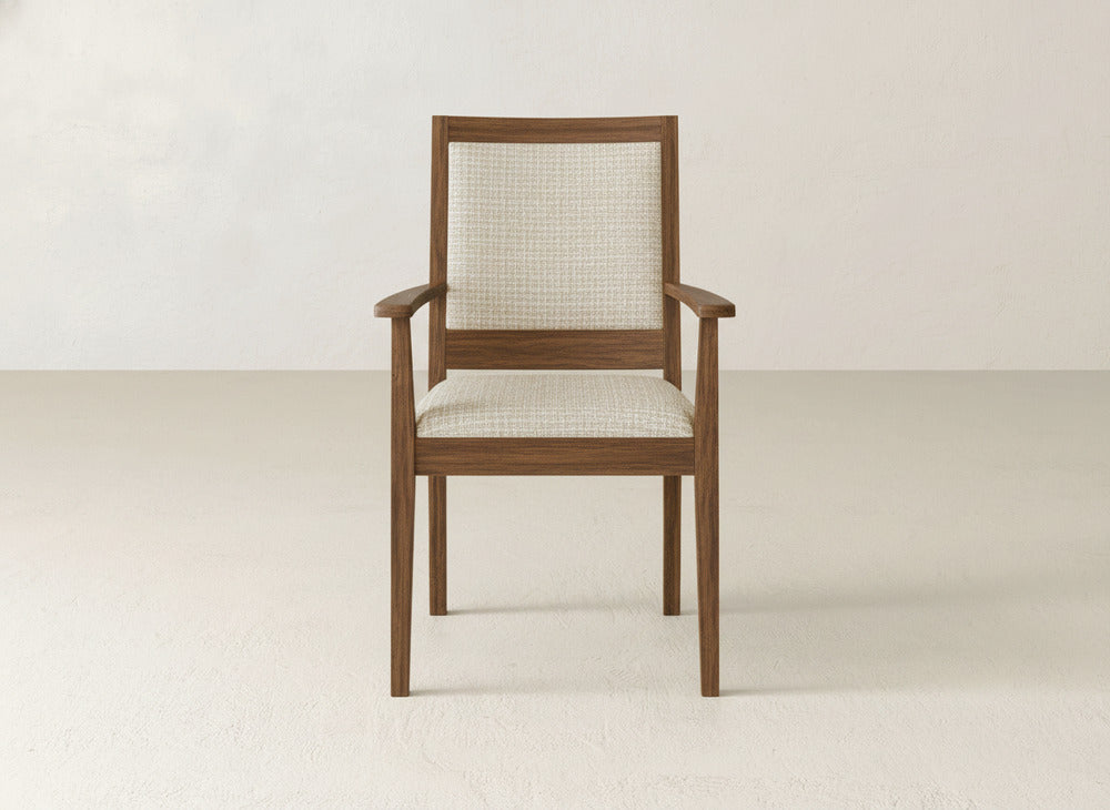 The Gina Arm Dining Chair by James+James is a contemporary maple wood chair with square armrests and a light beige upholstered seat and backrest, shown against an off-white background.
