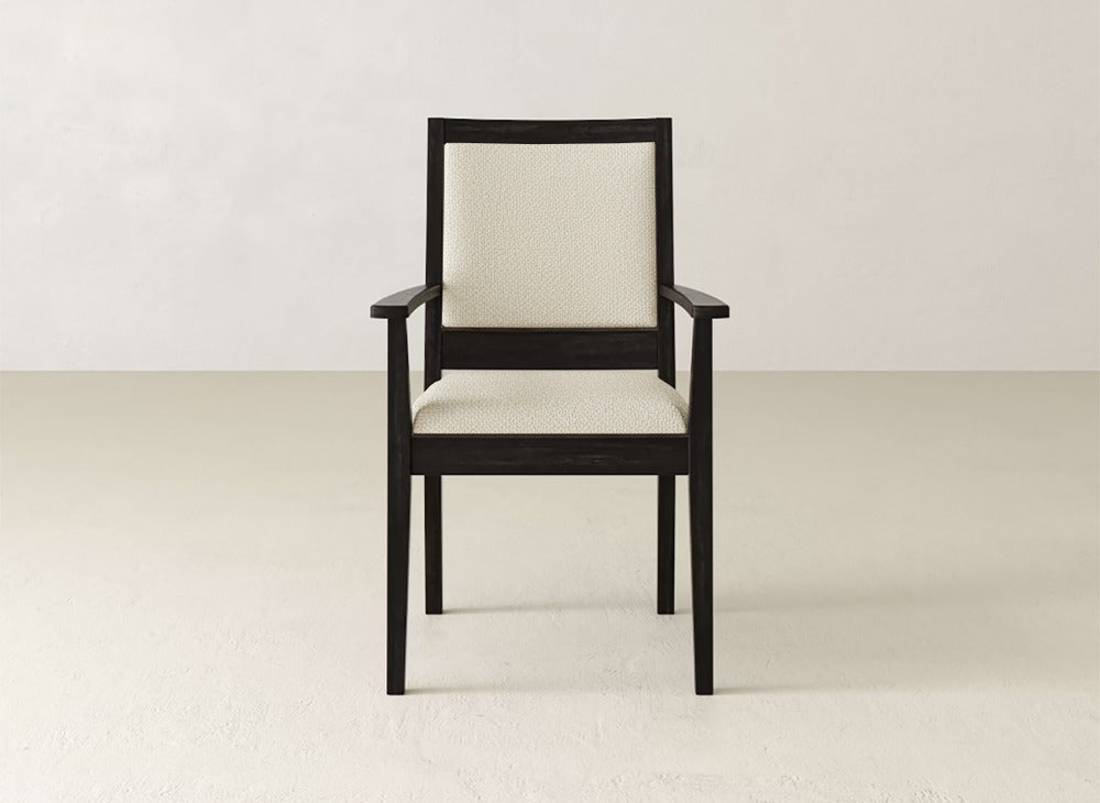 The Gina Arm Dining Chair by James+James showcases a maple wood frame in a deep finish with light cushioned seat and backrest, set against a plain, light background for a modern aesthetic.