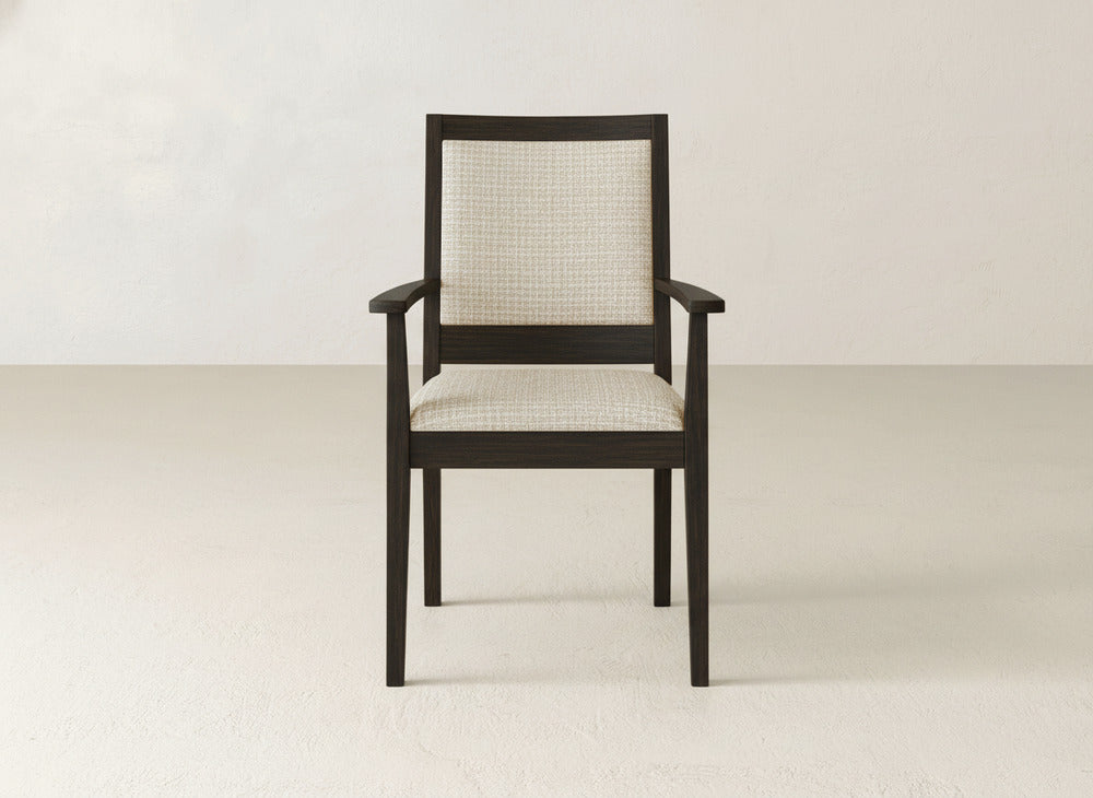 The Gina Arm Dining Chair by James+James features a contemporary design with a dark maple wood frame and light, textured upholstery on the seat and backrest.