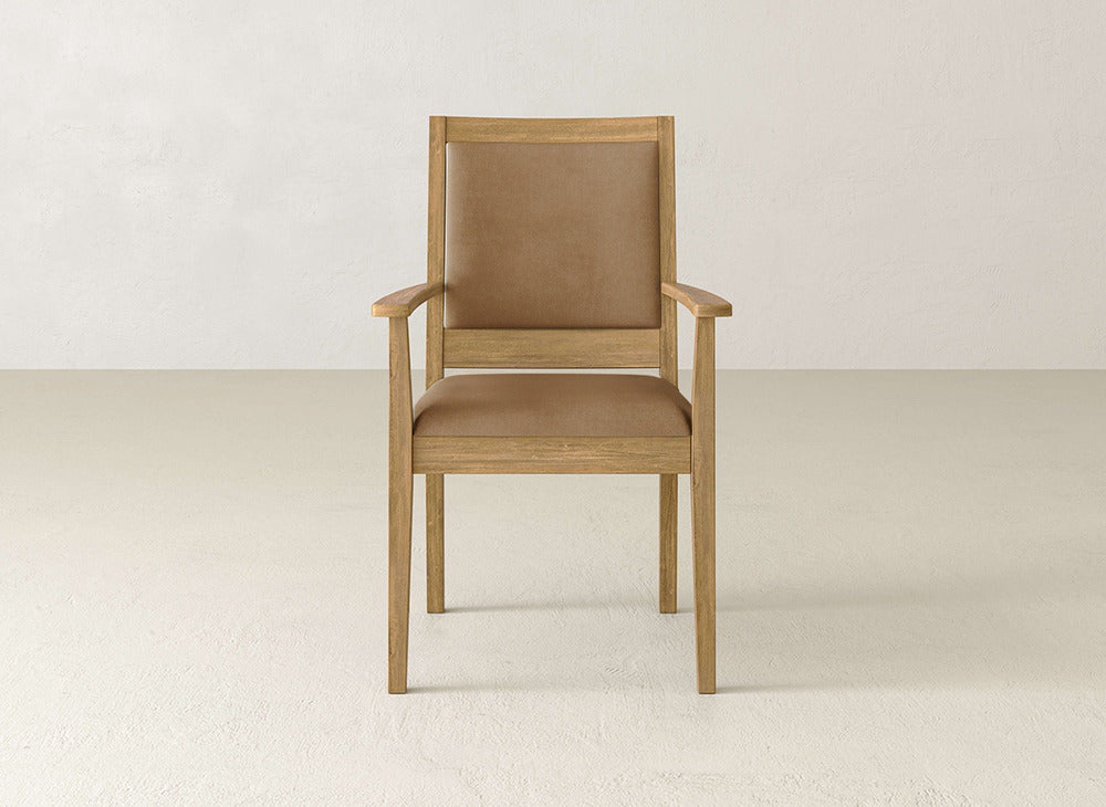 The Gina Arm Dining Chair by James+James features a maple wood frame, light brown legs, and a padded tan seat with a matching backrest, perfect for contemporary dining spaces.