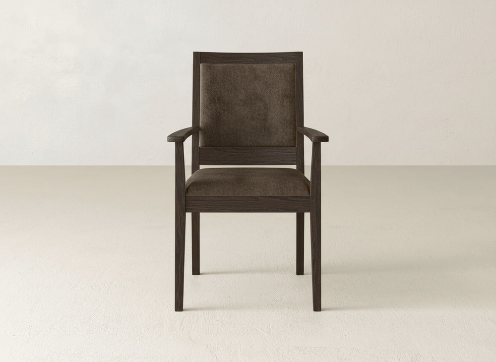 The Gina Arm Dining Chair by James+James features a dark maple wood frame and brown upholstered seat and back, making it a stylish choice for contemporary dining spaces.
