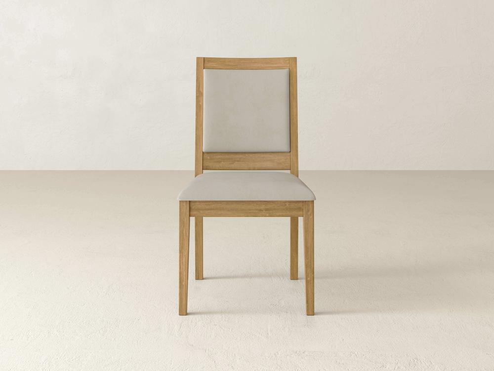 A wooden chair with a light-colored cushioned backrest and seat is centered on a plain beige background. The chair has a simple, minimalist design.