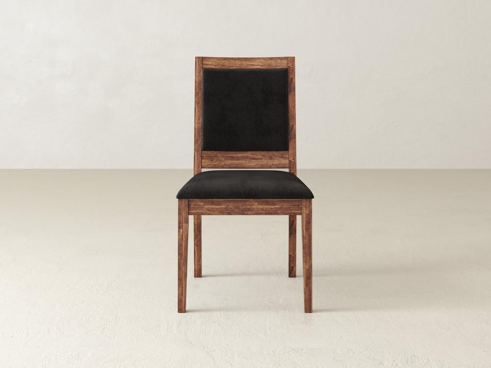 Wooden chair with a black cushioned seat and backrest, set against a plain, light-colored background.