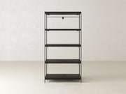 Minimalist black metal shelving unit with five tiers standing against a plain off-white wall and light-colored floor. The shelves are empty, highlighting the clean, sleek design.