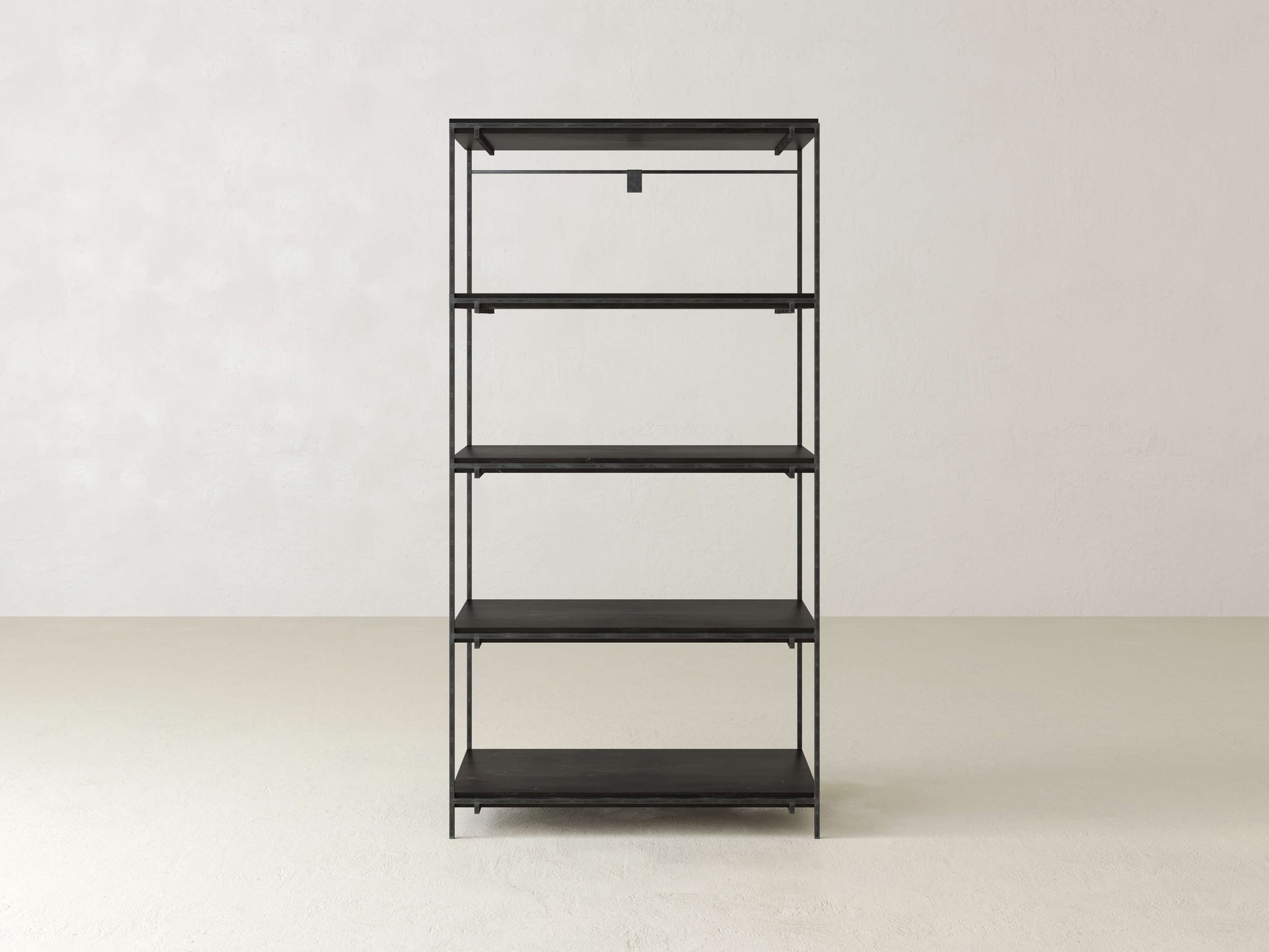Minimalist black metal shelving unit with five tiers standing against a plain off-white wall and light-colored floor. The shelves are empty, highlighting the clean, sleek design.