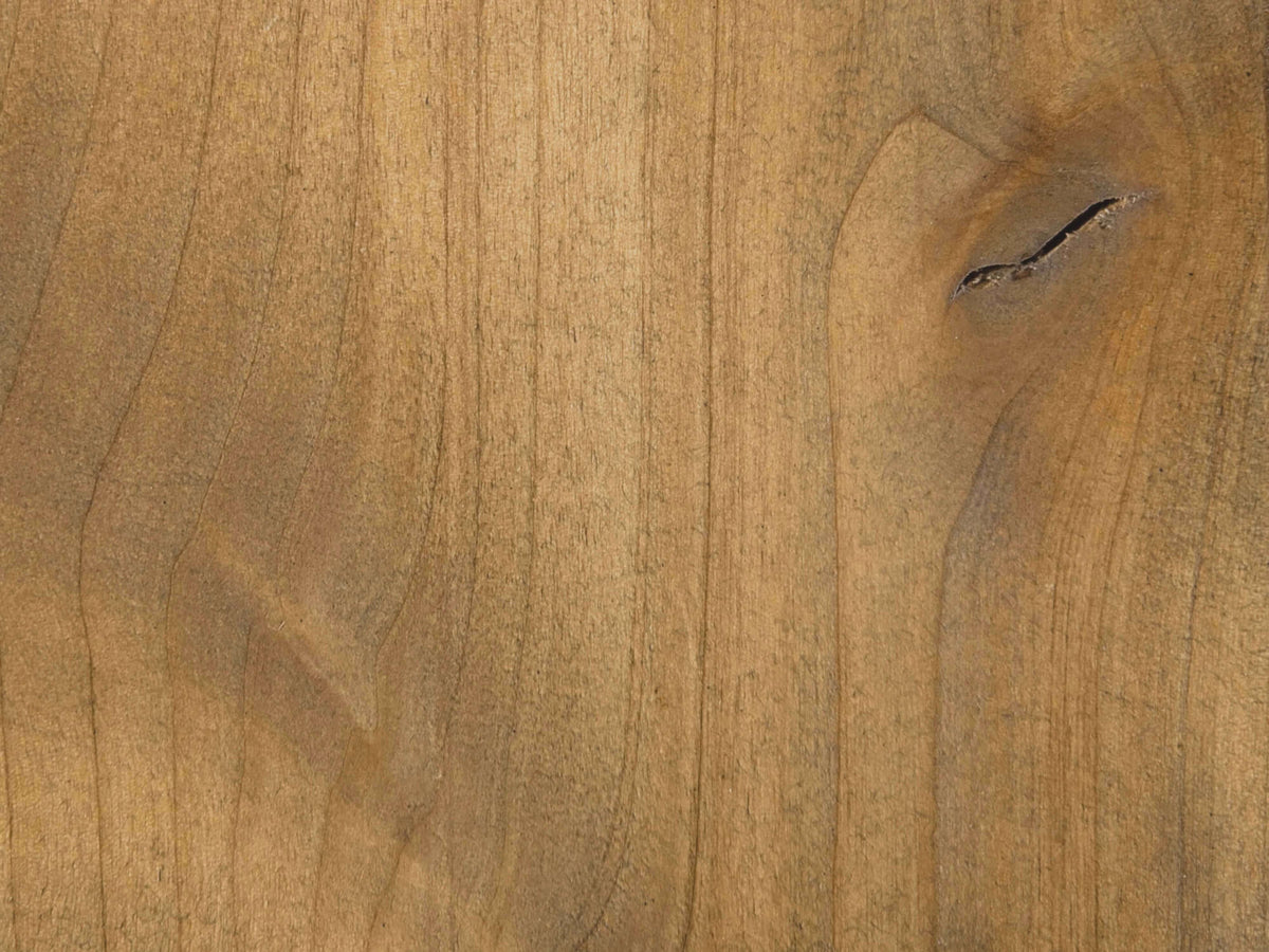 Close-up of a wooden surface with a smooth texture. The wood has a warm brown color with natural grain patterns and a visible knot on the right side, adding character to the otherwise uniform appearance.