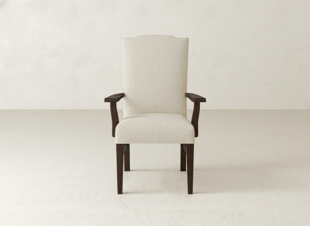 The Hadley Arm Dining Chair by James+James features cream upholstery, dark wooden arms and legs, and a high back, all set against a plain light background.