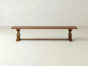 The Heirloom Bench - Almond on Oak by James+James features a flat wooden seat and two carved legs, shown against a plain white background.