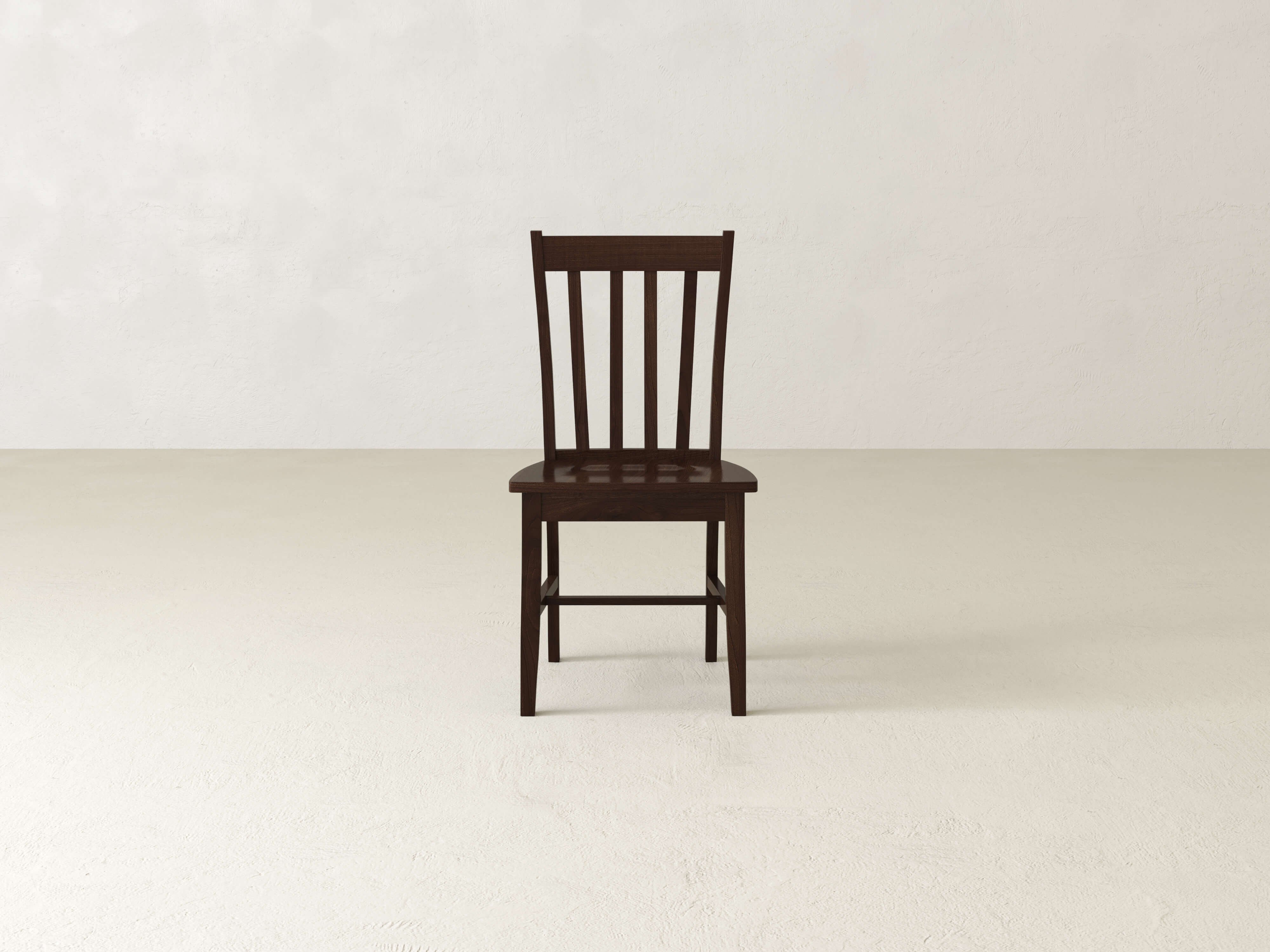 The Henry Dining Chair - Tobacco by James+James features a wooden design with a high backrest adorned with vertical slats. The chair boasts a dark wood finish and four straight legs, showcasing simple and sturdy construction. Its flat seat complements the classic and minimalist design, as shown from an angled rear view.