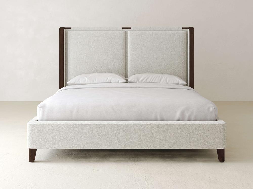 The James & James Holden Bed – Boucle is a modern, minimalist piece with a textured boucle headboard and light gray frame. Featuring two pillows and a neatly made, light-colored bedspread, its contemporary design stands out against an off-white background.