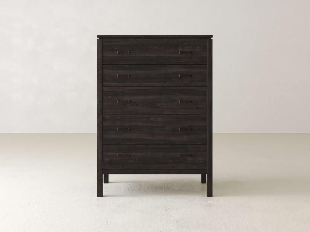 The Jensen Tall Chest by James & James, made from solid maple hardwood, stands against a light-colored wall. Its five sleek drawers feature simple handles, complementing the minimalistic and contemporary design of the room's smooth flooring.