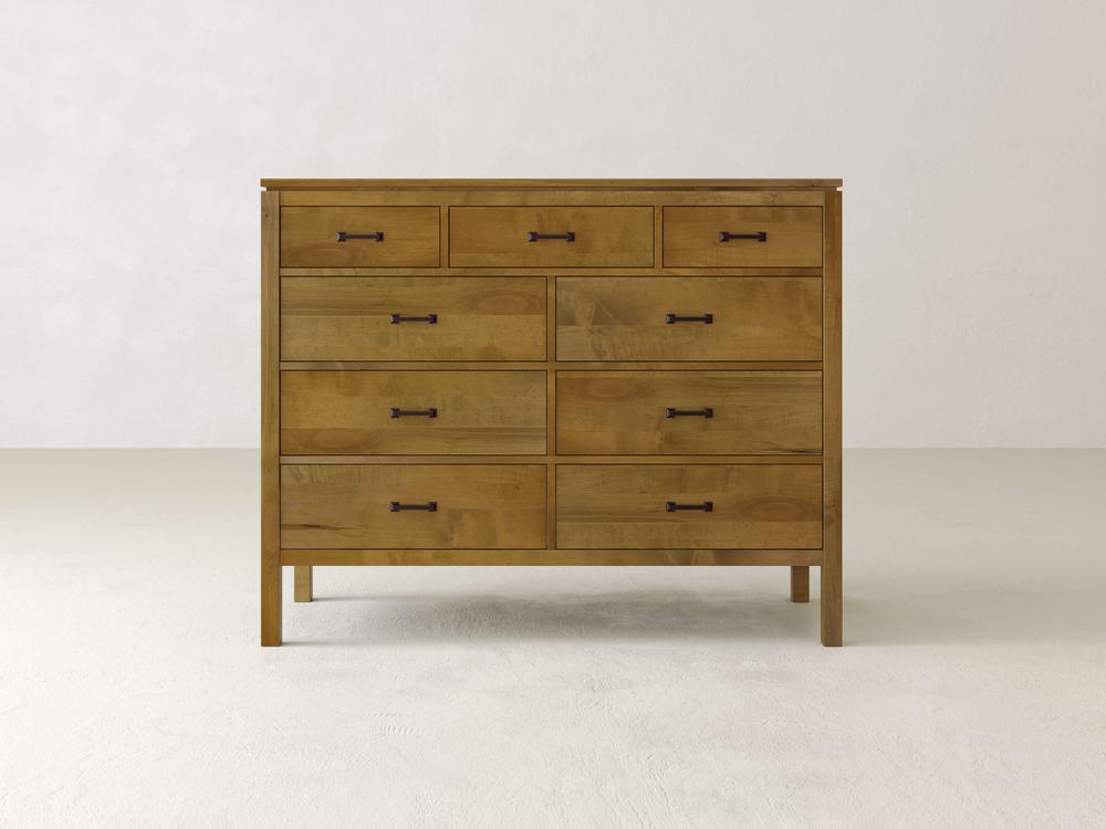 The James & James Jensen 9 Drawer Dresser, made of solid maple hardwood, is set against a plain white background. It features three smaller top drawers and six larger lower ones, all with simple black handles that complement its natural finish.