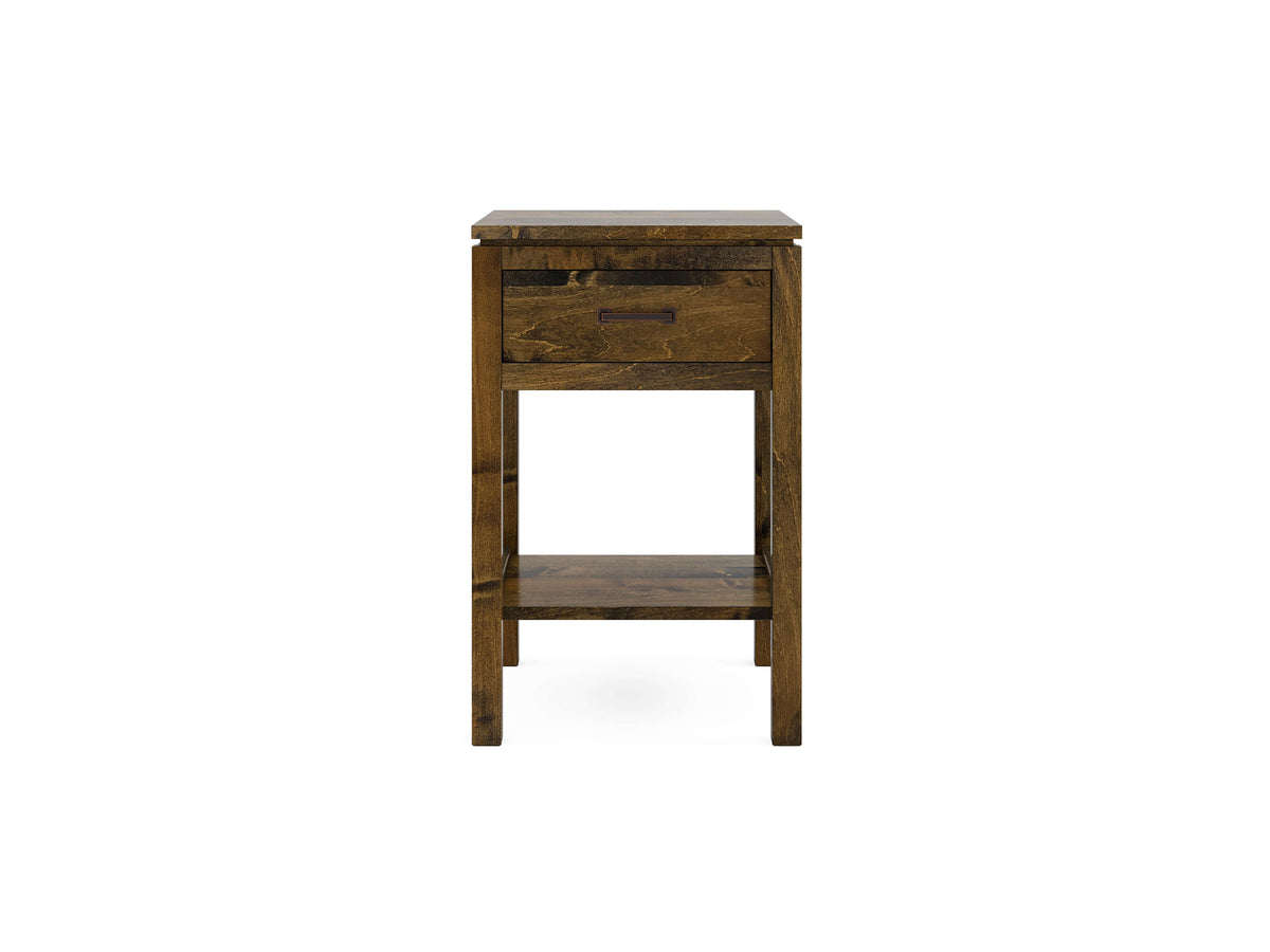 A narrow, wooden side table with a rustic finish. It features one drawer with a handle and an open shelf beneath. The table has a rectangular shape and sturdy, straight legs.