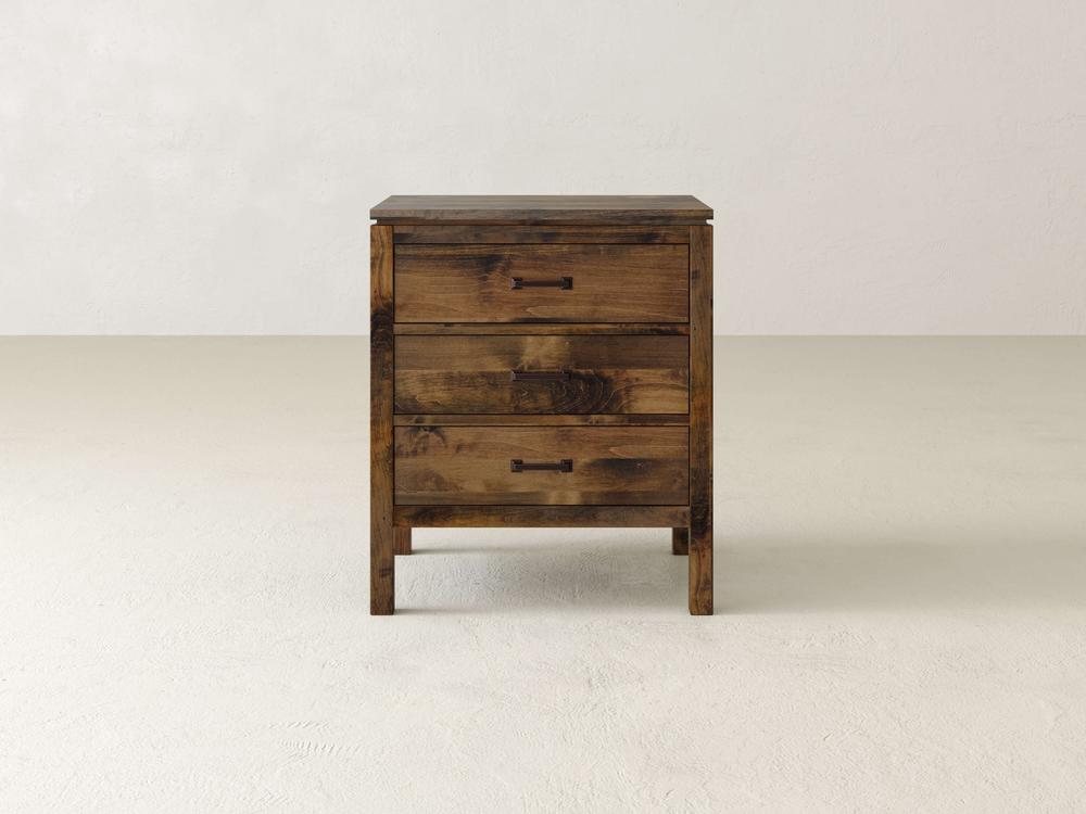 A James & James Jensen 3 Drawer Nightstand, crafted from solid maple hardwood, stands against a plain, light background. It features two spacious drawers with a rustic finish and simple metal handles for elegant bedside storage.