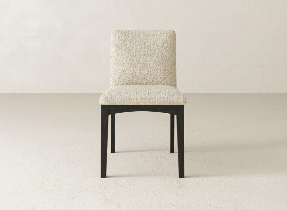 The Klein Dining Chair by James & James is a beige upholstered chair with textured fabric and maple legs, set on a light floor against an off-white background.