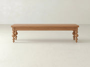 The Olivia Bench - Oak on Oak by James+James features a simple rectangular wooden seat with four turned spindle-style legs, shown against a plain, light-colored background.