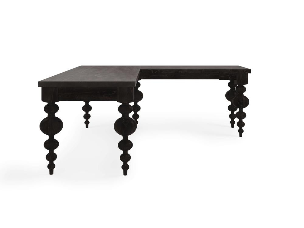 The Olivia Corner Desk - Charred Ember by James+James is a black L-shaped wooden desk featuring intricate, rounded legs. It boasts a corner configuration, offering two work surfaces. The elegant and traditional design, accentuated with a dark finish, showcases the craftsmanship of the legs.