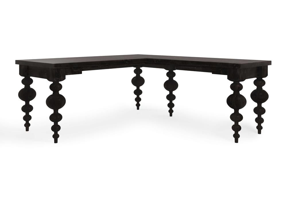 The Olivia Corner Desk - Charred Ember by James+James features an L-shaped design with intricate, spindle-like legs. The desk has a smooth, flat surface, and each leg is adorned with bulbous, ornate details stacked vertically. This design combines modern lines with a classic, decorative touch.