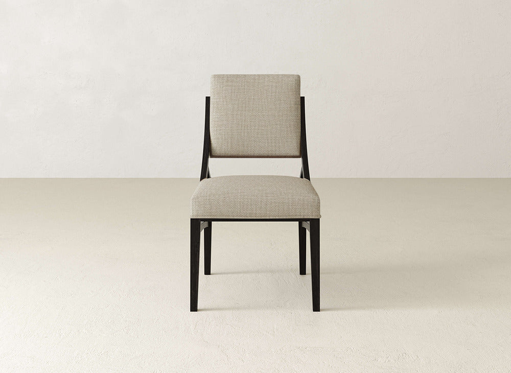 The Quinn Dining Chair by James+James features a light beige cushioned seat and backrest with a black metal frame, creating a modern look that enhances any dining room decor.
