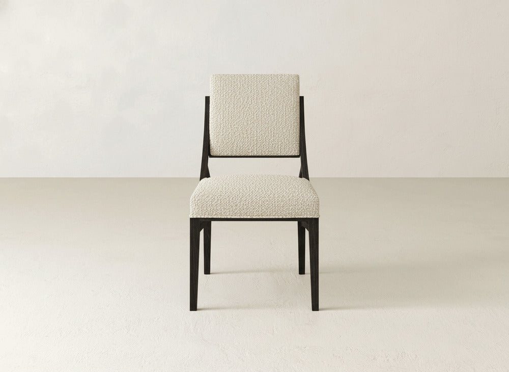 The Quinn Dining Chair by James+James features modern upholstery, a dark wooden frame, and a light textured seat and backrest—an ideal choice to enhance your dining room decor.