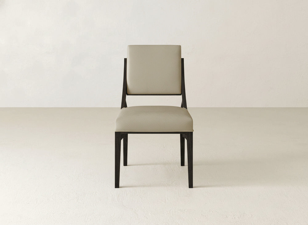 The Quinn Dining Chair by James+James is a modern upholstered dining chair with a cushioned beige seat and backrest, a dark wooden frame, and a simple light background—ideal for elevating your dining room decor.