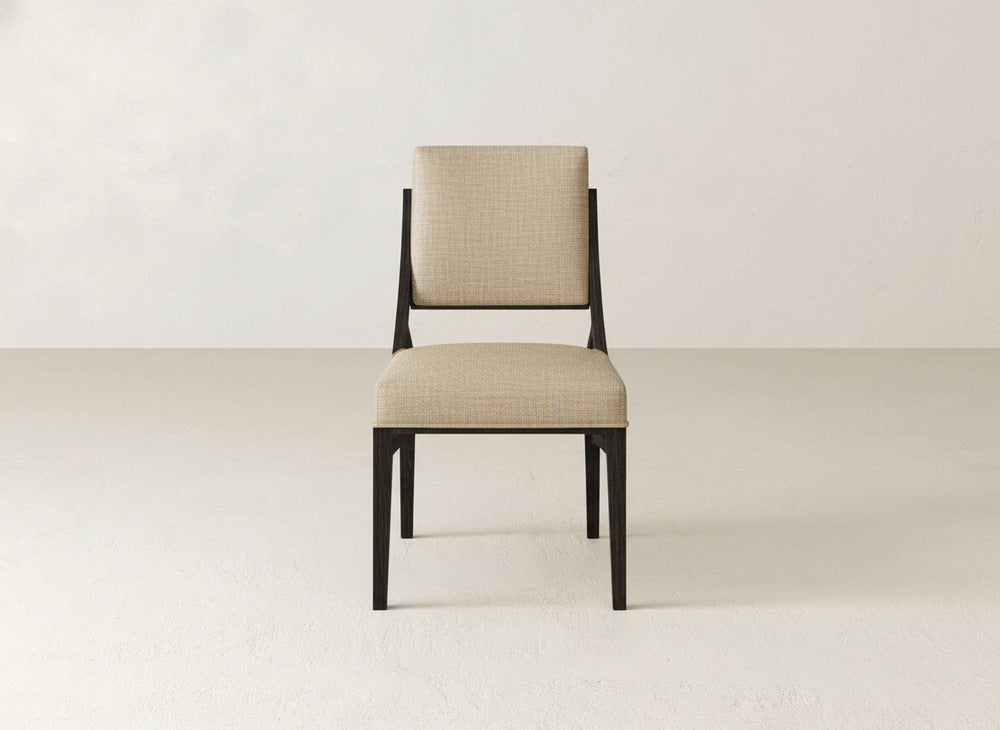 The Quinn Dining Chair by James+James features a simple, modern design with a beige upholstered seat and backrest and dark wooden legs, making it an elegant addition to any dining room.