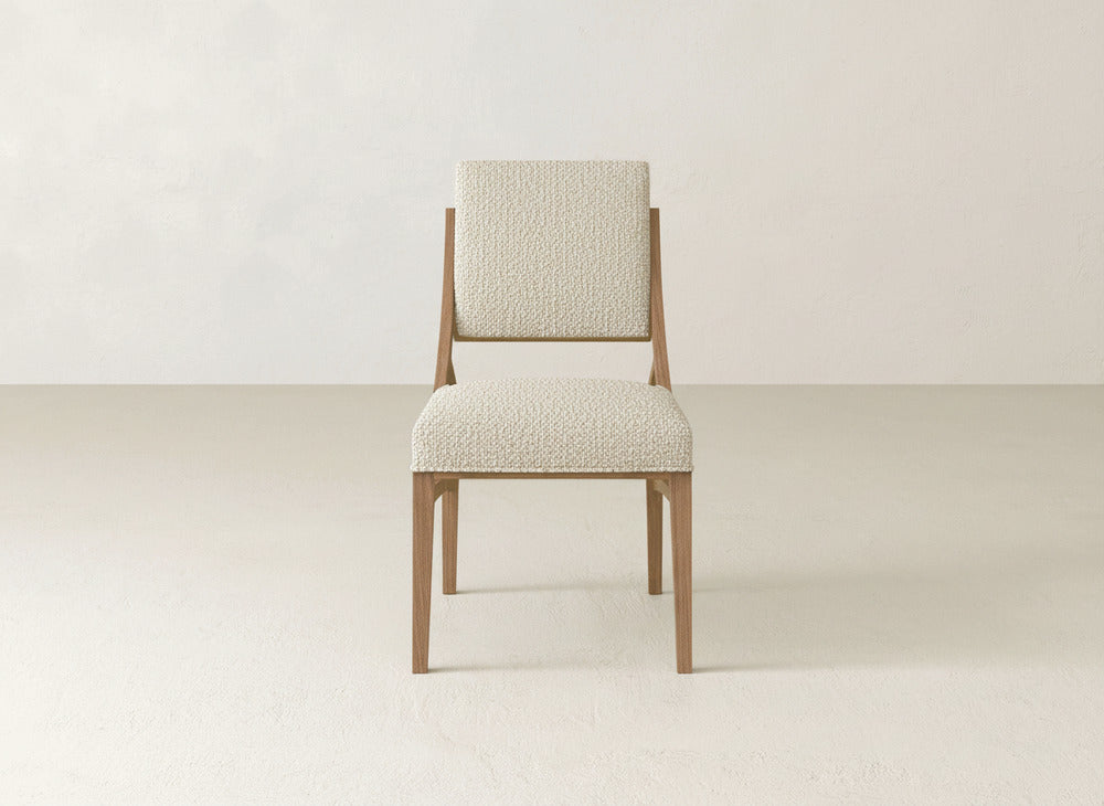 The Quinn Dining Chair by James+James features a modern light wood frame and textured off-white upholstery, perfect for enhancing your dining space with stylish comfort against any neutral decor.