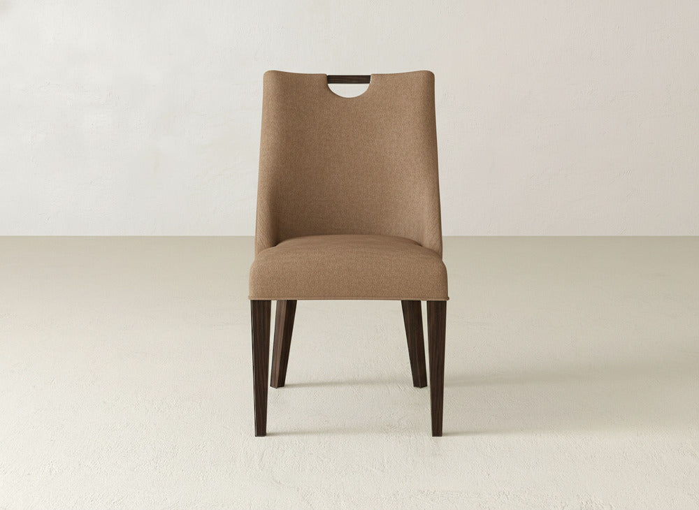 The Rosalie Dining Chair by James & James features brown upholstery, dark wood legs, and a simple high backrest with a small cutout, creating a modern look perfect for contemporary interiors.