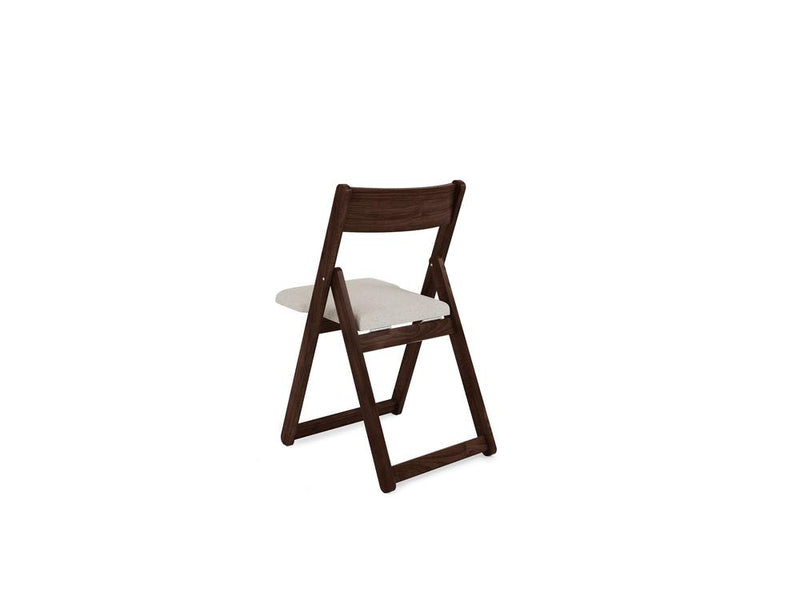 A wooden folding chair with a cushioned beige seat and backrest is positioned at an angle, showing both the front and side. The design is sleek and minimalist, suitable for compact spaces.
