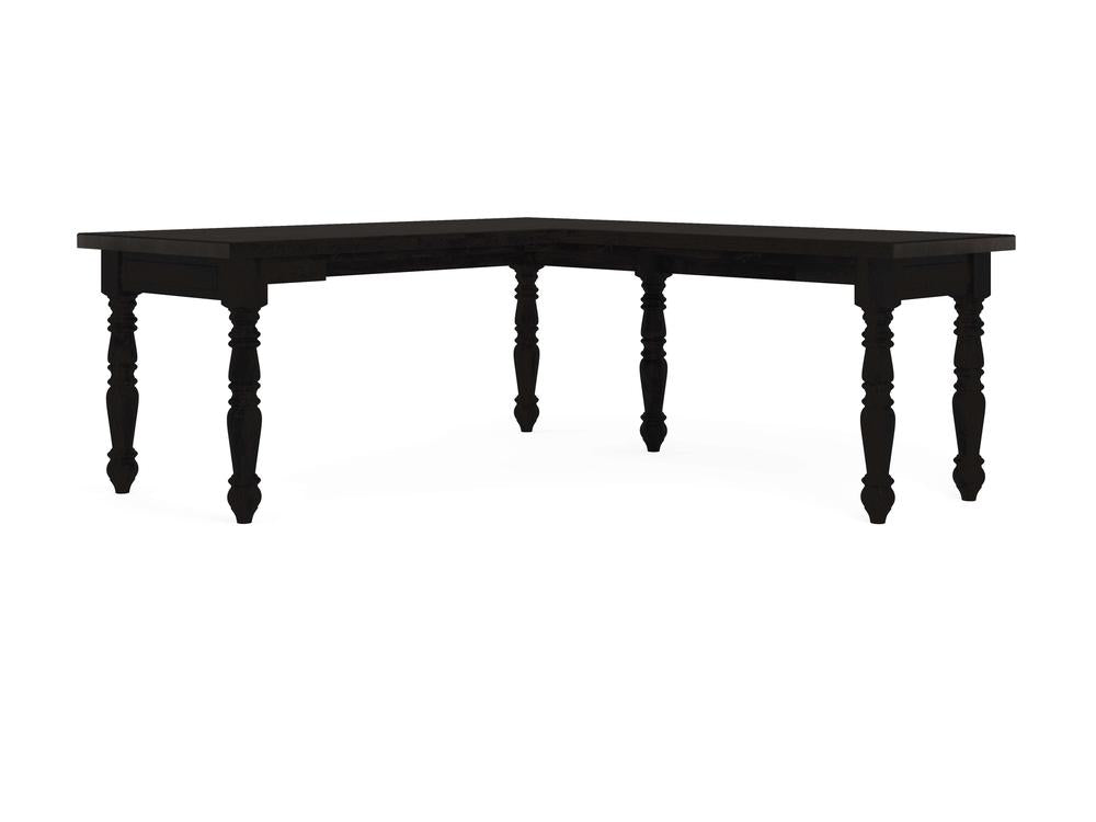 The Turned Leg Corner Desk - Charred Ember by James+James features a classic and elegant design, with a black L-shape supported by four intricately carved wooden legs. The desk's surface is smooth, making it an ideal addition to any dining room or office setting.