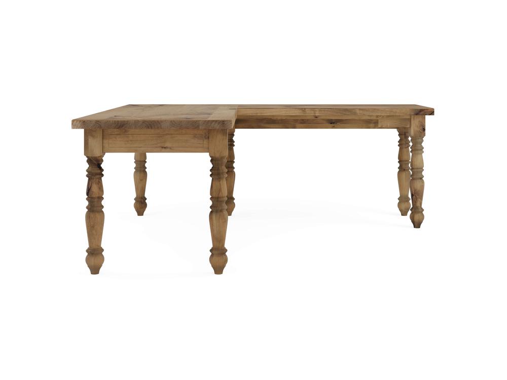 The "Turned Leg Corner Desk - Harvest Wheat" by James+James is a wooden L-shaped table featuring intricate carvings on the legs, with a natural wood finish and a classic, rustic design.