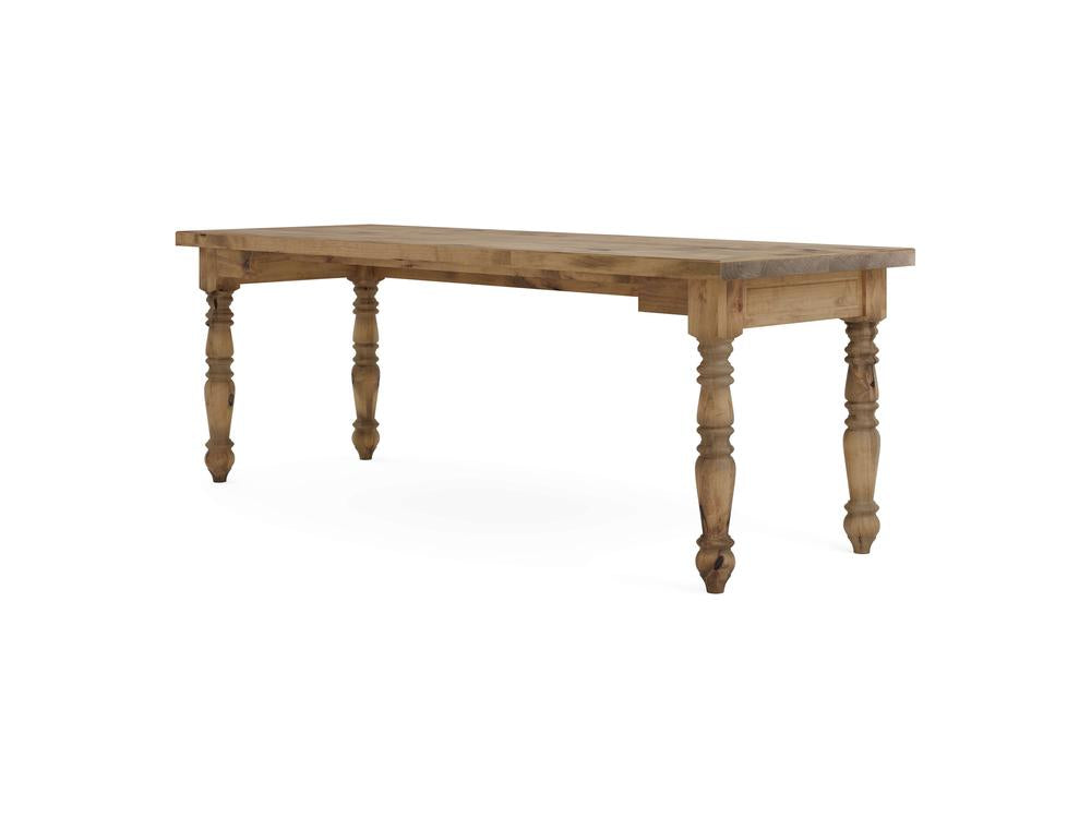 The Turned Leg Desk - Harvest Wheat by James+James is showcased against a simple white background, highlighting its wooden construction and rustic finish. It features a rectangular top supported by four intricately carved legs.