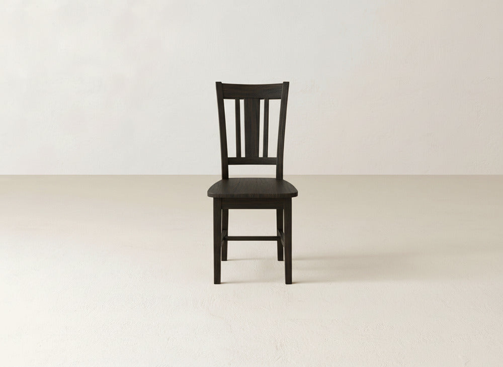 A single James+James William Dining Chair with a slatted backrest is centered in a bright, empty room, adding a stylish accent to any dining space or home décor.