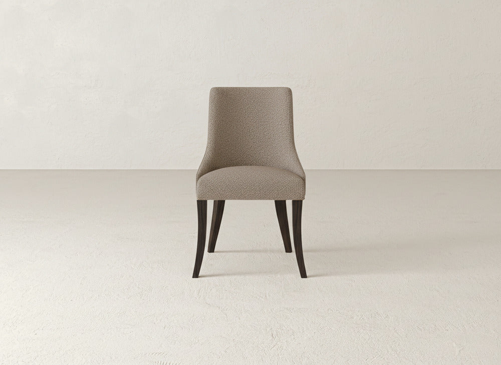 The James+James Willow Dining Chair features a modern curved backrest and dark wooden legs, set on a light-textured floor against a plain, light wall.