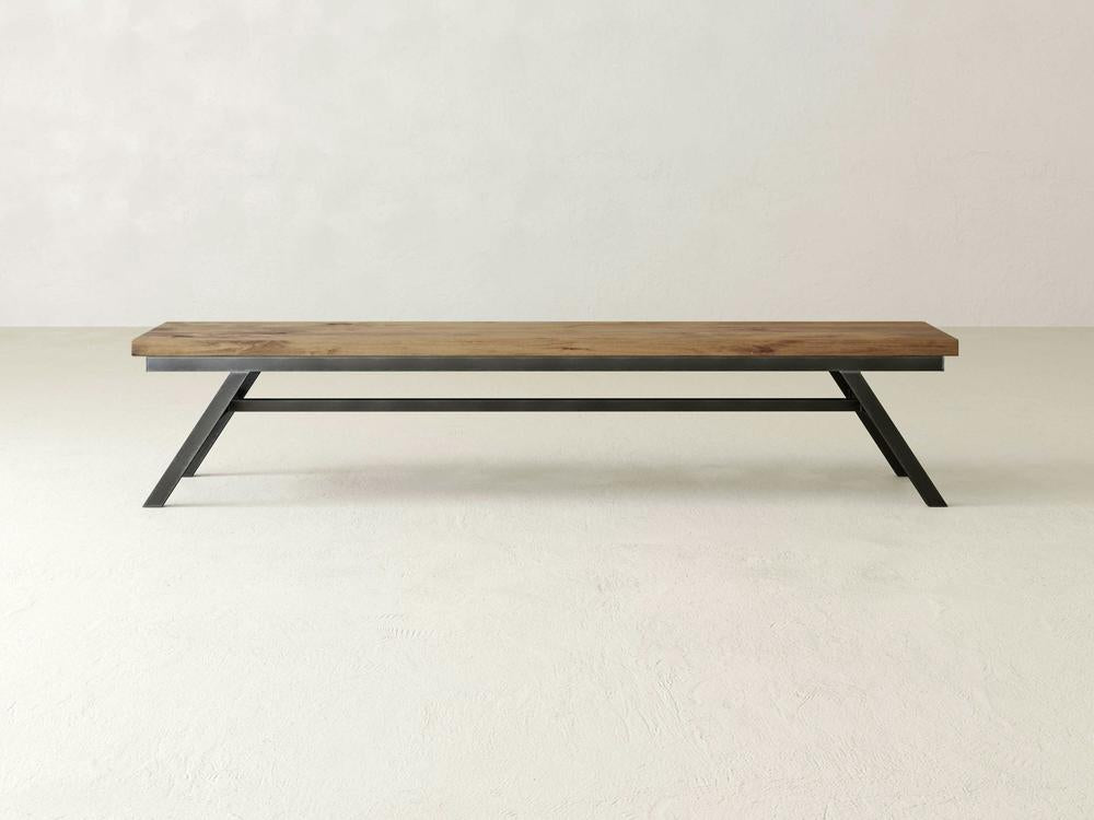 The James+James Fulton Bench - Harvest Wheat on Alder features a minimalist rectangular wooden top and angled black metal legs, shown against a plain white background.