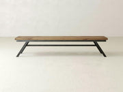 The James+James Fulton Bench - Harvest Wheat on Alder features a minimalist rectangular wooden top and angled black metal legs, shown against a plain white background.