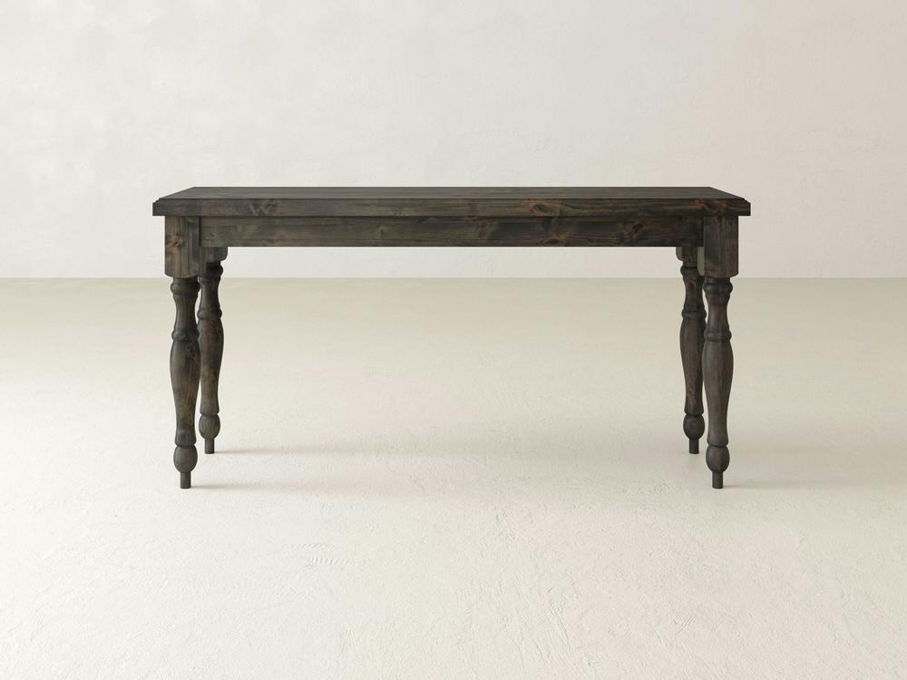 A dark wooden James+James Abigail Sofa Table with a rectangular top and four intricately carved legs is set against a plain, light-colored background. Its timeless charm is evident in the classic and robust design.