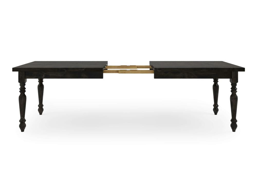 The French Country Expandable Dining Table - Charred Ember by James+James is shown. The table, characterized by its dark wooden finish, features four turned legs and a central split down the middle with visible metal extension mechanisms. It is partially extended, showcasing its adjustable feature with a gap in the center.