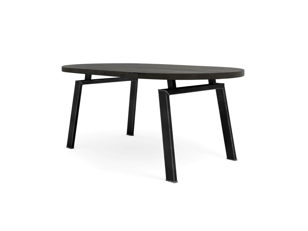 The Fulton Oval Dining Table - Charred Ember by James+James features a modern oval-shaped design with a dark wooden top and black metal legs. With its minimalist aesthetic, clean lines, and sturdy frame, this table is perfect for a variety of interior settings.